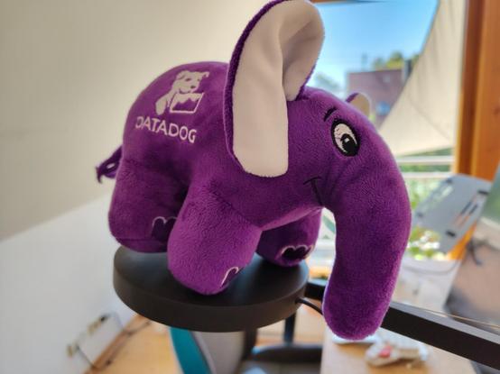 A violett elephant plushi featuring the logo of datadog