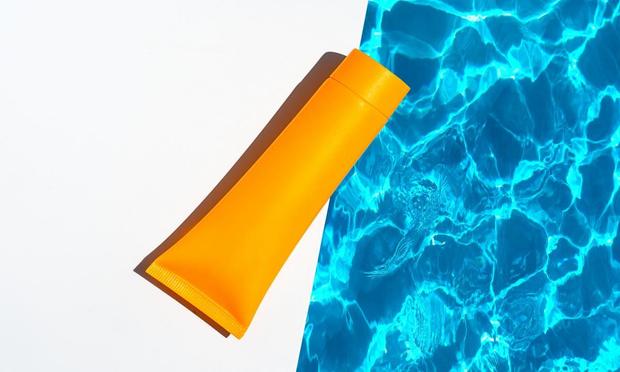 Un bote de crema solar junto a una piscina (Getty Images)