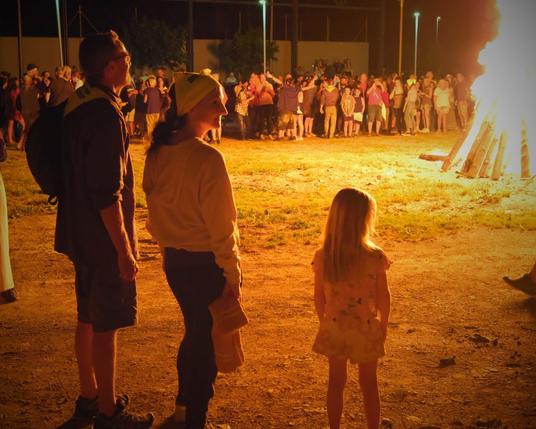 Bonfire of the huge falle in the village. A crowd watches.