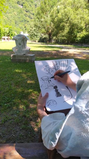 Même parc, même sculpture, et au premier plan une personne en train de dessiner la sculpture à l'encre de Chine