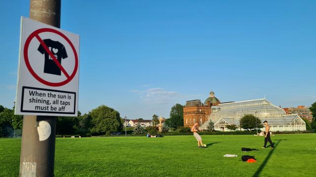 A sign saying When The Sun Is Shining, alAll Taps Must Be aff in a Glasgow Park.