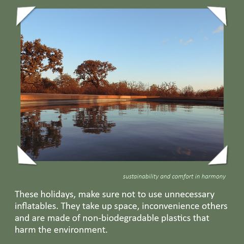 The serene pool of Bubulcus & Bolotas, reflecting the sky and nearby trees under a clear blue sky. The image is framed with a green border and white corner accents, with text emphasizing sustainability: "These holidays, make sure not to use unnecessary inflatables. They take up space, inconvenience others and are made of non-biodegradable plastics that harm the environment." Subtext reads: sustainability and comfort in harmony.