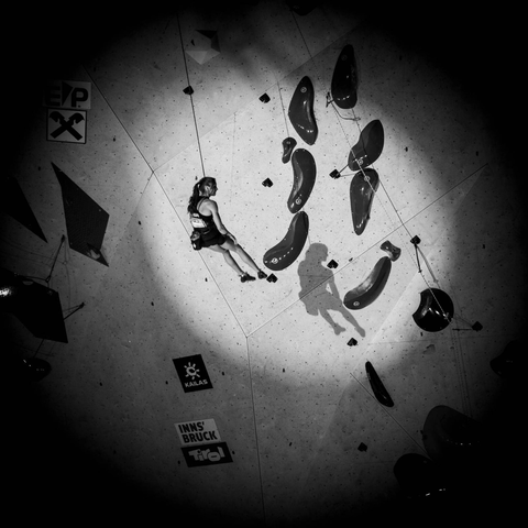 Climber hanging on a rope and the shadow on the wall.