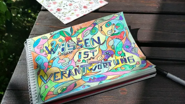 Mit Buntstiften gekritzeltes Bild. Ein Schriftzug ist zu erkennen:
Wissen ist Verantwortung