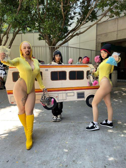 Grupo de tres mujeres haciendo un cosplay de Breaking Bad. En medio una chica vestida de la camioneta, del lado derecho una mujer con bikini amarillo, botas amarillas, una máscara de gas en una mano y en la otra dinero, tiene la barba de Walter White. Al lado derecho una mujer con un bikini amarillo, el gorro de Jesse Pinkman y una bolsa con la droga azul de la serie y su mascar a de gas en la otra mano