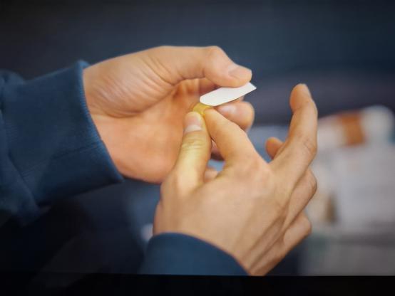 Still from Our unwritten Seoul with a close up of the male lead hands applying a band-aid all ny himself with a first aid kit in the back ground that he had to get himself as well