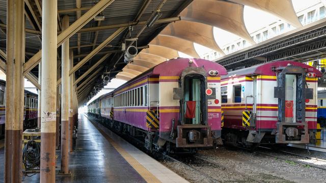 photo of one of the passenger train station platform with two trains stationed on the right side of the platform