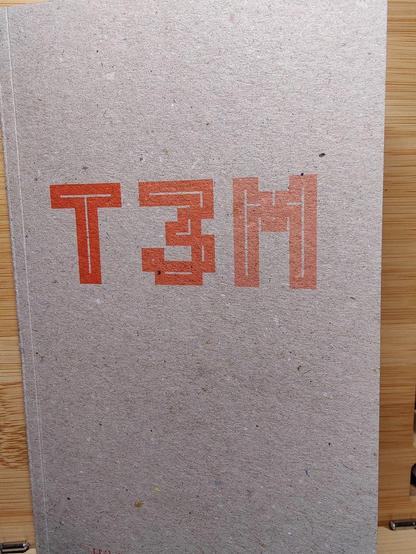Couverture de T3M, publié aux éditions du commun.

Photo d'une couverture cartonnée, marron, sur laquelle sont écrites en grosses lettres orange "T3M", et puis en bas le nom de l'autrice en plus petit : Héloïse Brézillon.