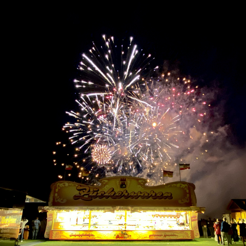 Foto eines Feuerwerks mit Jahrmarkt-Bude darunter; photography of a firework