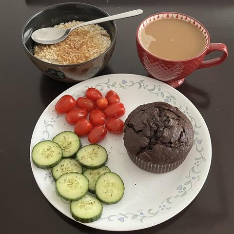 I had a bowl of oatmeal topped with brown sugar, seasoned and sliced cucumbers and grape tomatoes, a chocolate muffin, and a cup of almond coffee