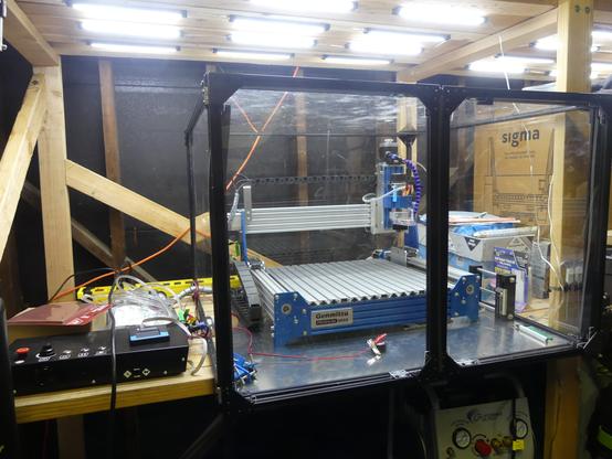 Genmitsu ProverXL 4030 CNC aluminum router in a box made of 20mm black extruded aluminum with aluminum floor and acrylic side panels and front french doors.