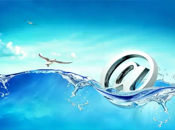 a "frutiger aero" type of image showing a giant chrome at-symbol in a wave of water. there are seagulls in the background