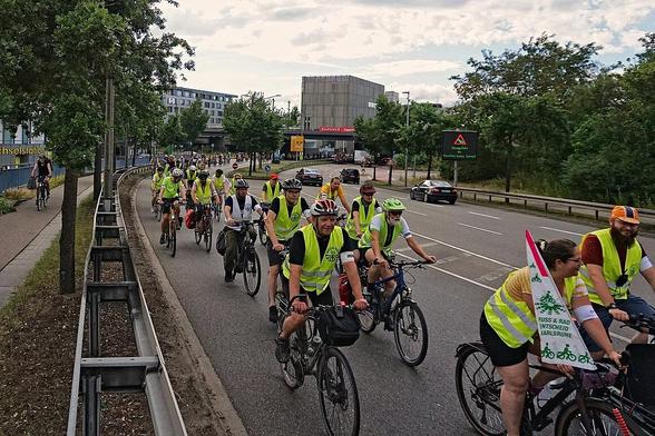 Radfahrende auf der Rampe zur Wolfartsweierer Brücke. Blick auf dem Ordnerblock an der Spitze