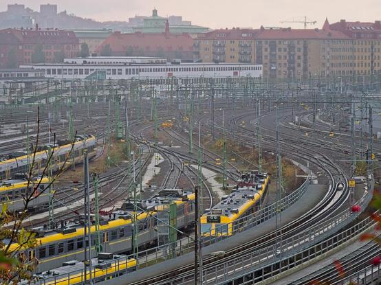 Vy över Göteborg sedd från Skansen Lejonet. Vi ser den förvirrande bangården från skansen bort mot Göteborg central, med mängder av järnvägsspår, elektrisk apparatur, tågset. I bakgrunden ser vi bostadsfastigheter.