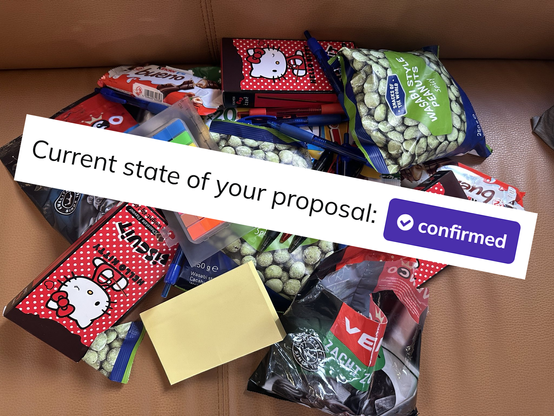 Pile of snacks used during Team:Content session. With text "Current stat of your proposal: confirmed" plastered on top of it
