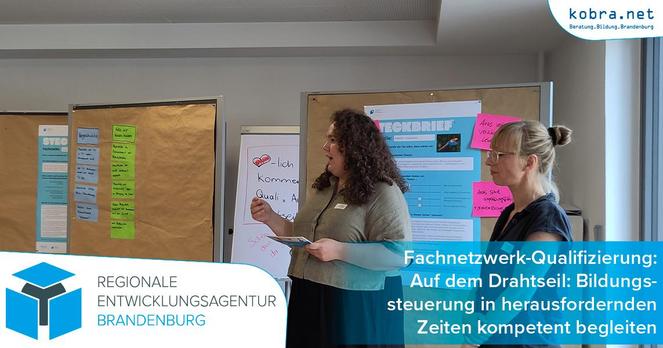 Katharina Vogel und Antje Materna referieren im Workshop einer Fortbildung. Sie stehen in einem Raum vor Pinnwänden, auf denen verschiedene Zettel mit Konzepten und Ideen angebracht sind.