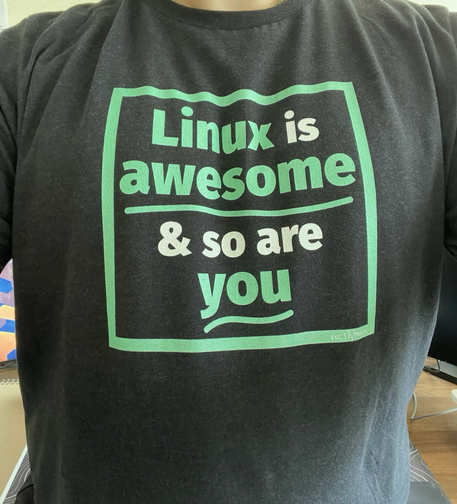 A photo of an awesome black and green shirt from creator “Veronica Explains”. It says “Linux is awesome, & so are you”.