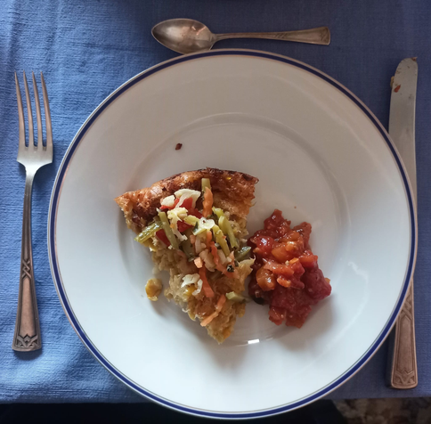 Ein Stück von dem Maispfannkuchen auf dem Teller mit Mixed Pickels und Chutney