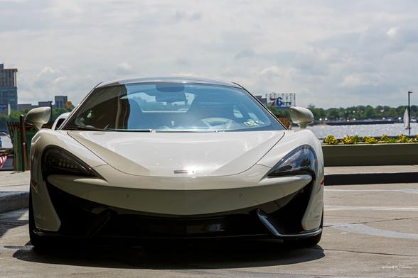 Front view of McLaren 570S showing speedmark-inspired LED headlights, carbon splitter, and aerodynamic bonnet under natural light