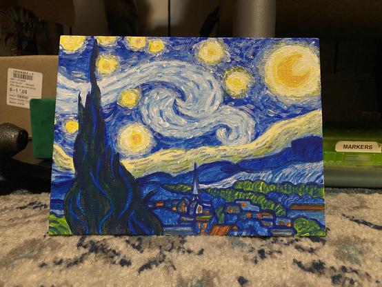 A colorful painting depicting a night sky filled with swirling stars and a bright moon, resembling Van Gogh's style. In the foreground, there are dark cypress trees and a village with buildings beneath the sky. The artwork showcases vibrant blues and yellows.