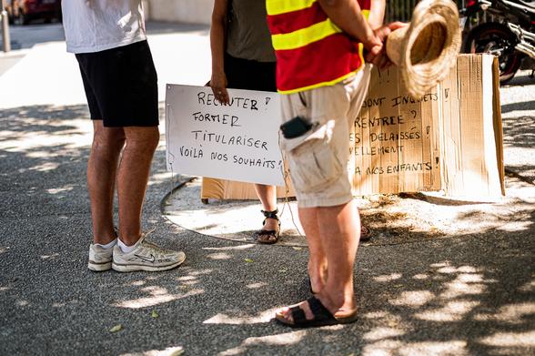 quelqu'un tenant une pancarte: Recruter, Former, Tutulariser voila nons souhaits!