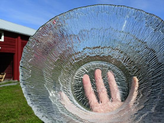 We see a cristal bowl which is inspired by Arctic Landscapes which is hold against the blue sky.