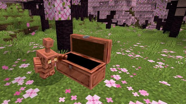 A screenshot of a copper golem standing next to an open copper chest inside a cherry blossom grove.