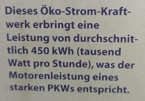 Ei Foto eines Texts in blauer, dicker Schrift:
"Dieses Öko-Strom-Kraft-werk erbringt eine Leistung von durchschnit-tlich 450 kWh (tausend Watt pro Stunde), was der Motorenleistung eines starken PKWs entspricht."