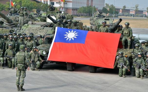 Members of Taiwan’s 564th Armored Brigade hold their flag after demonstrating their ability to repel an airborne attack near Kaohsiung, Taiwan, Jan. 11, 2023. Credit: Seth Robson/Stars and Stripes