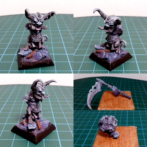 Picture of a mini, frame split into four panels.
Top left, top right and bottom left : different angles of a dwarf figurine, it got horns, a tail and an angry face, it's on a black square base with dark blue rocks.
Bottom right : the dwarf's weapons, a huge scythe and a shield having a face skin on it, with big fangs.

The whole mini is basecoated in shades of grey and some blue tints here and there.
