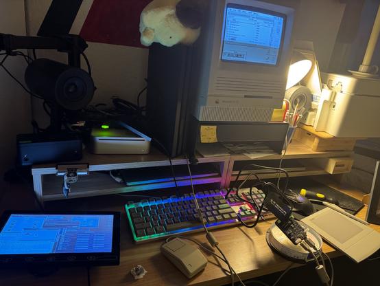 Desk with a mac mini hooked up to a tiny utility monitor, using an ADB moue via a wombat. A Mac SE/30 with an ArtPad II copying DiskWarrior onto an AFP share (a raspberry pi). Assorted clutter.