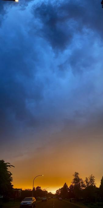 A very tall vertical (panoramic but sideways) shot of a sunset sky. Bright yellow at the horizon, turning to deep orange, turning to pale and deep blue.