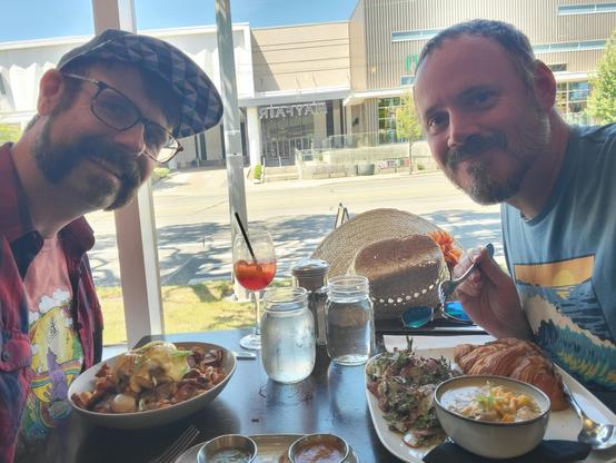 My husband and I posing with our brunch. I'm having breakfast poutine and a blackberry aperol spritz. My husband gas a chicken corn chowder, strawberry salad and a ham and cheese croissant.