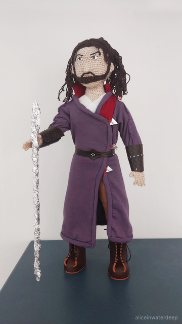 The same doll from the previous picture, now holding a silver wizard staff in his right hand.