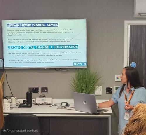 A presenter with a digital presentation screen showing the words 'Leading Digital Change: A Conversation'