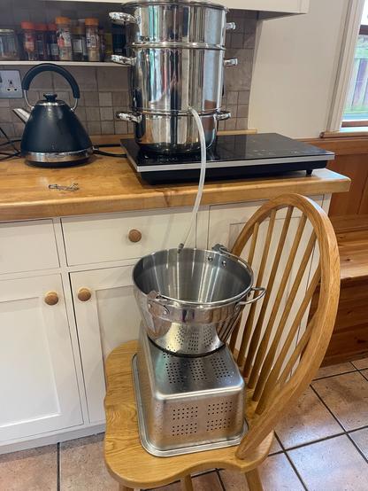 Steam juicer on the side in the kitchen with a pipe out of it to go in a cauldron sitting on the chair below. Took over 4hrs to juice it all!