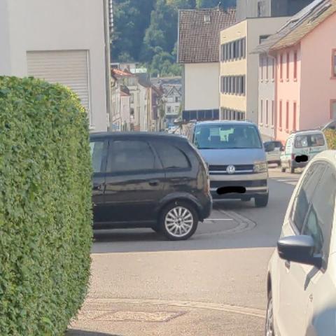 Ein schwarzer Kleinwagen parkt im Kreuzungsbereich auf dem barrierefrei ausgebauten Gehweg. Die Sichtlinie zum gegenüberliegenden Gehweg ist versperrt.