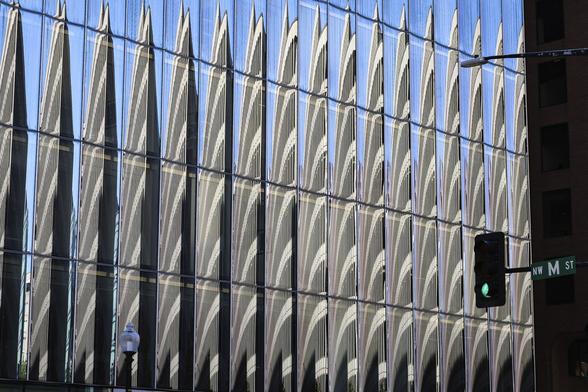 Multiple reflections of a tower-building in a building covered with glass-panels In Washington DC.