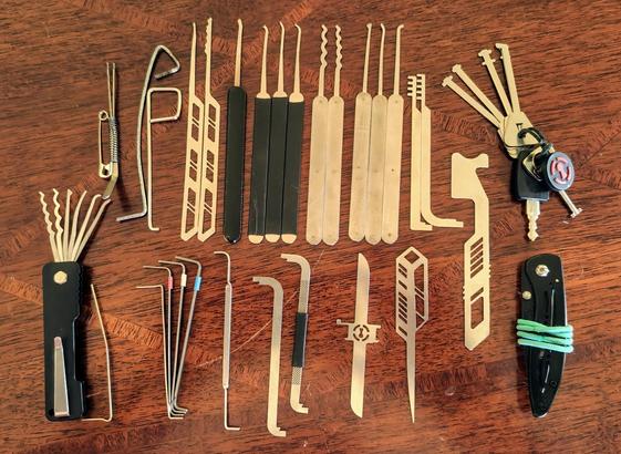 27 lockpicks, 4 bypass tools, 9 tension tools, a TSA007 key, a small pocket knife, and two hair ties.