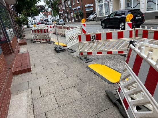 Baustellen auf dem Fußweg, die Fußgänger, Rollstuhlfahrer, … werden über den Parkstreifen geführt. Hierfür müssen sie eine steile gelbe Rampe überwinden. Für einen ca. 3 Meter langen Abschnitt müssen sie wieder hoch, um dann wieder runter. Besser wäre es, wenn sie unten weiter gehen / rollen könnten.
