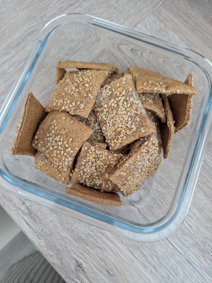 Aus glutenfreiem Sauerteig gebackene viereckige Cracker (wie Knäckebrot) bestreut mit Sesam und Meersalz