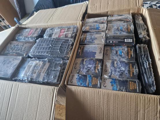 Two parcels filled to the brim with plastic sprues in boxes and shrink wrap