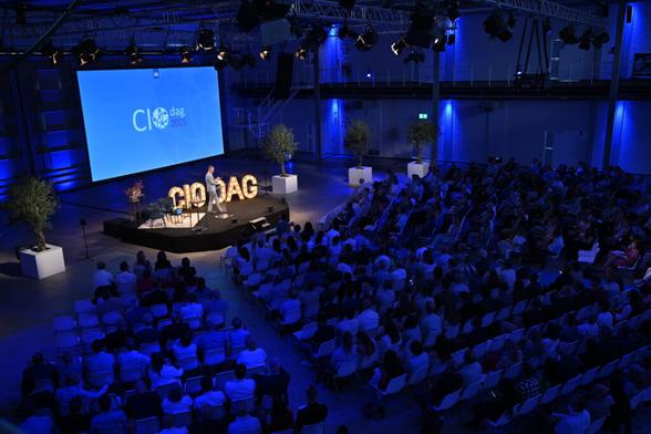 Overzichtfoto van zaal met spreker Art de Blaauw, CIO Rijk.