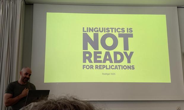 Timo presenting a slide that reads in huge letters Linguistics is NOT READY for replications.