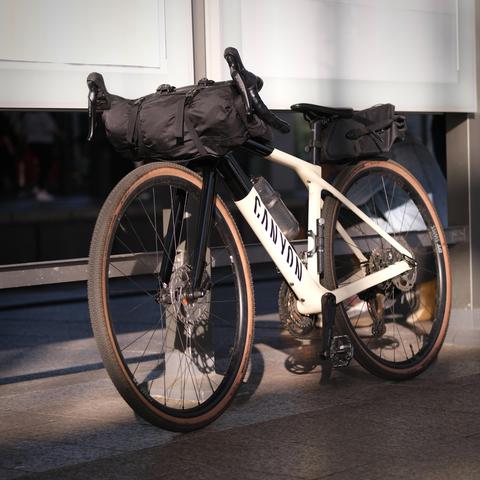 Canyon Gravelbike mit eine Lenkertasche und Arschrskete, die so gerade noch zwischen Sattel und Hinterrad passt.
