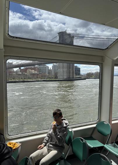 Cool angled windows on the cruise around Manhattan. Here we’ve gone under a bridge, don’t know which. A child is seen sitting in the foreground, the bridge is now seen more from the side.