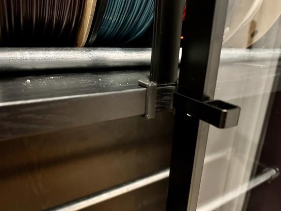 The same BILLY shelf, clip, and channel are shown from a different angle.  In this photo, one of the glass doors is almost closed in front of the channel.