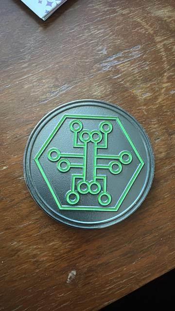 a challenge coint wiyh a green Hackers.town logo