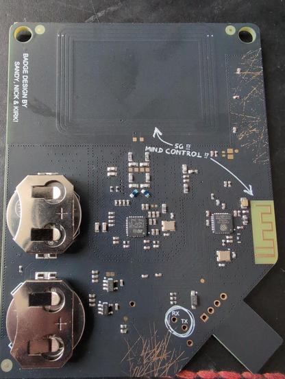 BSides Vancouver badge back, holding 2 coin cell batteries, what appears to be ab antenna in the circuit board and more connectors.
