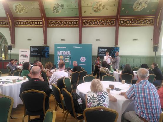 Photo: a beautiful hall with three speakers at the front in front of a screen